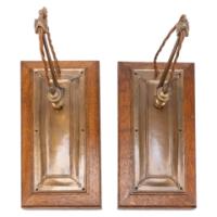 Birmingham Guild of Handicraft. A rare pair of Arts & Crafts patinated bronze wall lights with subtle raised decoration to the back plates and extending arms with oak wall frames - Thumbnail 1
