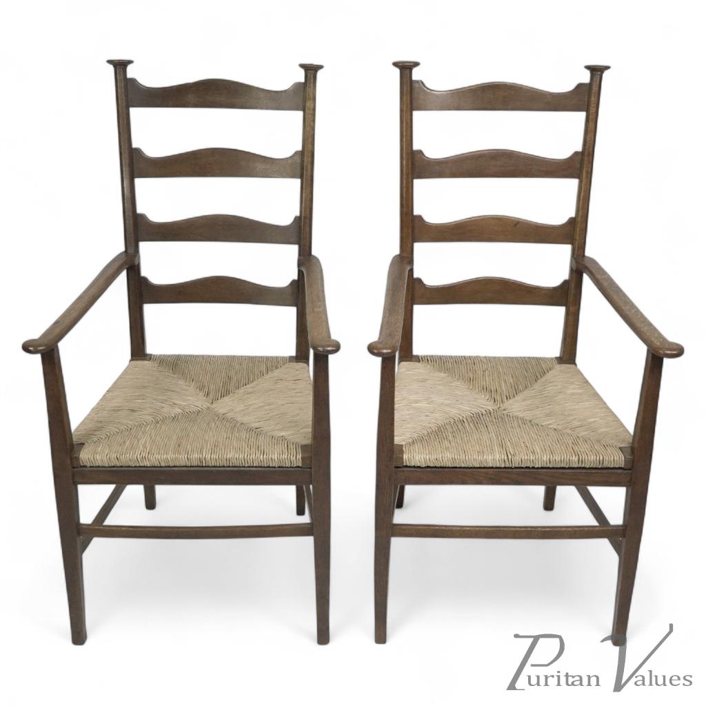 Liberty & Co., Style of C. F. A. Voysey. A Pair of Oak Rush Seat Ladderback Armchairs - Image 1