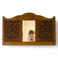 Arthur Simpson. An Arts Crafts mirror with shaped top, the central bevelled mirror, flanked by stylised carved floral details. - Thumbnail 1